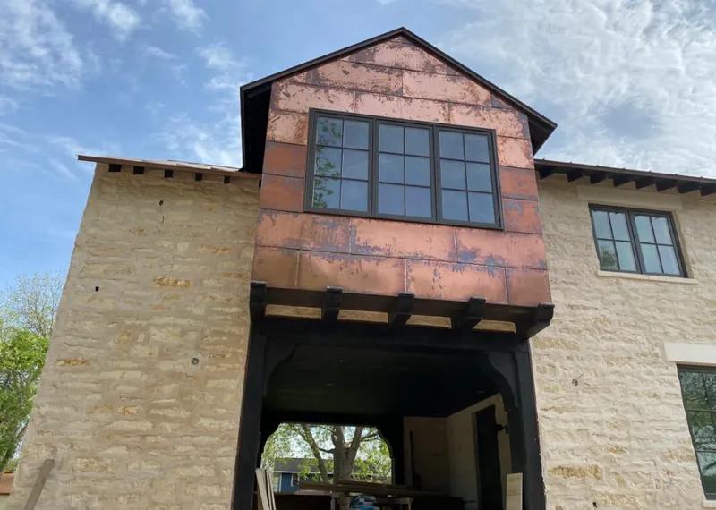 Copper metal panel facade on a stone building for Roof Repair in Northchase
